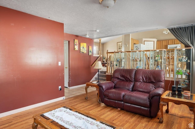 3139 S Timeron Dr, West Valley City, UT 84128 - living area featuring light wood-style floors, stairs, a textured ceiling, and baseboards