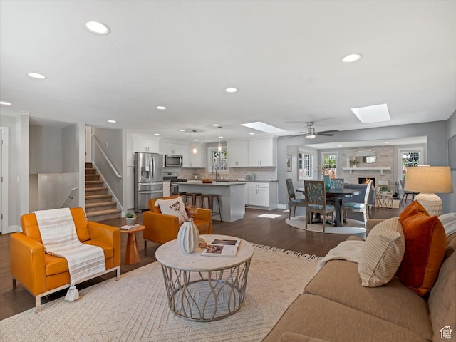 1555 E Fieldcrest Ln, Holladay, UT 84117 - living area with a skylight, dark wood-style flooring, recessed lighting, ceiling fan, and baseboards