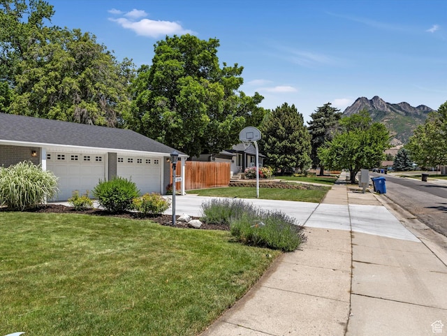 1555 E Fieldcrest Ln, Holladay, UT 84117 - view of yard featuring concrete driveway, a mountain view, and a garage