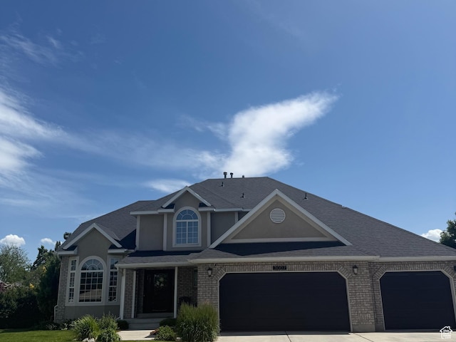 3007 W Sweet Clover Ln, South Jordan, UT 84095 - view of front of property with brick siding, a garage, stucco siding, and driveway