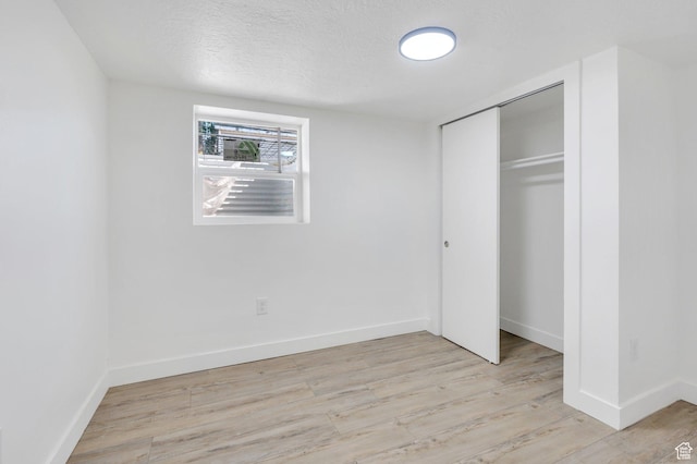 520 S Jeremy St W, Salt Lake City, UT 84104 - unfurnished bedroom with light wood-style flooring, a textured ceiling, a closet, and baseboards