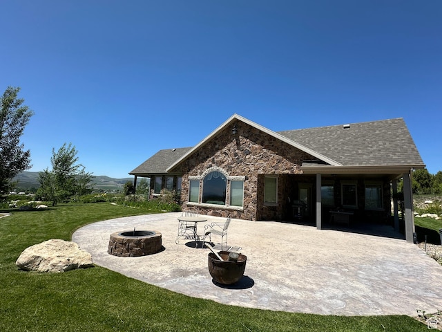 11730 E 24200 N, Fairview, UT 84629 - rear view of house with an outdoor fire pit, a lawn, a patio area, stone siding, and roof with shingles