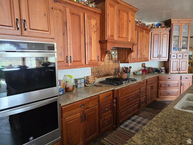 11730 E 24200 N, Fairview, UT 84629 - kitchen with stainless steel appliances, glass insert cabinets, backsplash, brown cabinets, and a textured ceiling