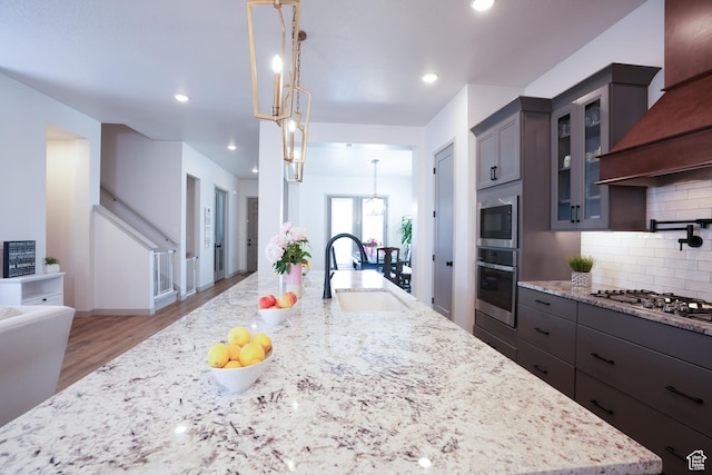 11579 S Pebble Pond Rd, South Jordan, UT 84009 - kitchen featuring appliances with stainless steel finishes, a sink, tasteful backsplash, light wood finished floors, and light stone counters