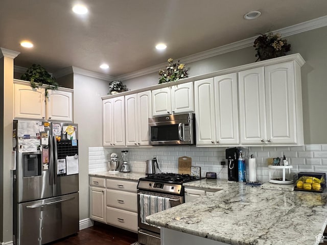 1107 E 1625 N, North Logan, UT 84341 - kitchen featuring appliances with stainless steel finishes, a peninsula, ornamental molding, backsplash, and white cabinetry
