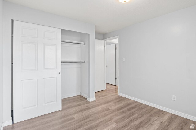 1522 W 1200 N, Layton, UT 84041 - unfurnished bedroom featuring light wood finished floors, a closet, and baseboards