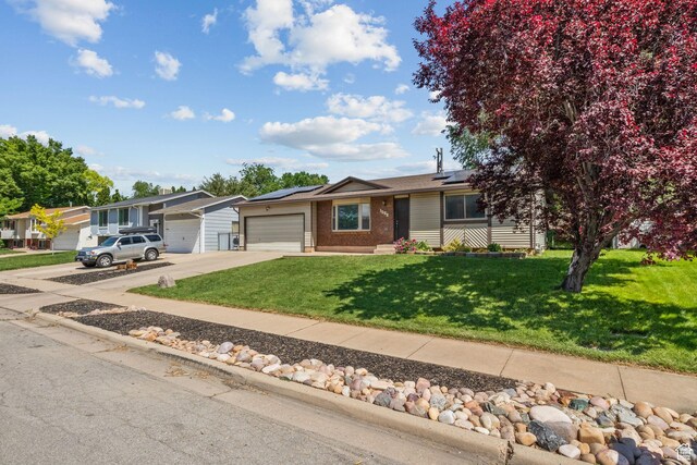 1522 W 1200 N, Layton, UT 84041 - view of front facade with an attached garage, brick siding, driveway, a front lawn, and solar panels