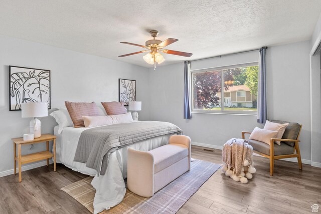 1522 W 1200 N, Layton, UT 84041 - bedroom featuring wood finished floors, a textured ceiling, baseboards, and a ceiling fan