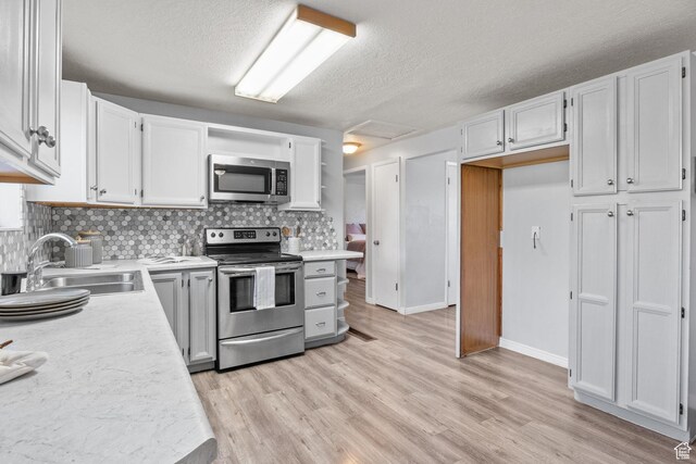 1522 W 1200 N, Layton, UT 84041 - kitchen with stainless steel appliances, a sink, a textured ceiling, light countertops, and decorative backsplash