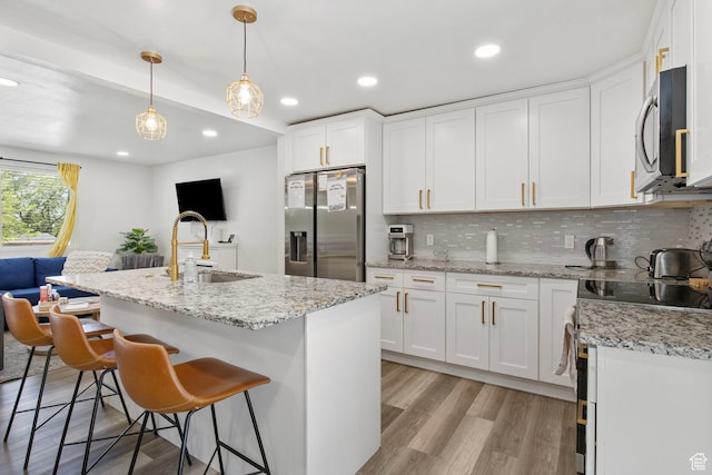 8485 S 1575 E, Sandy, UT 84093 - kitchen featuring stainless steel appliances, a sink, decorative backsplash, white cabinetry, and light wood-style floors