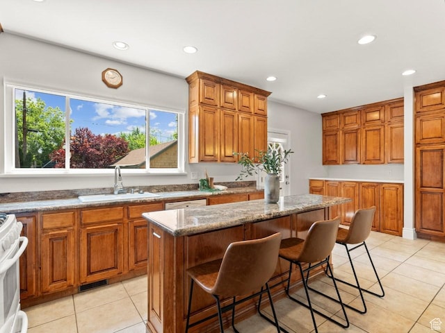 1146 E Harvard Ave S, Salt Lake City, UT 84105 - kitchen featuring a sink, brown cabinets, recessed lighting, light tile patterned flooring, and a breakfast bar area
