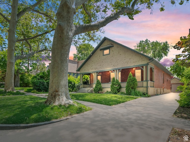 1146 E Harvard Ave S, Salt Lake City, UT 84105 - view of front of home featuring brick siding, a yard, covered porch, and concrete driveway