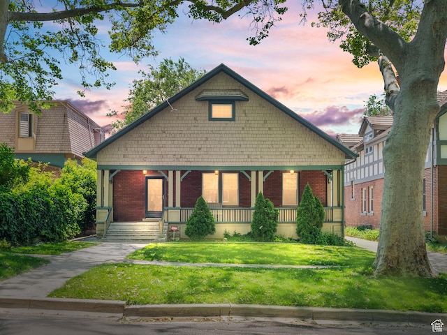 1146 E Harvard Ave S, Salt Lake City, UT 84105 - view of front of house featuring covered porch, brick siding, and a front yard