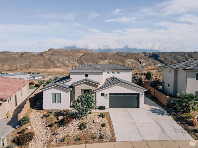 583 N Staci Dr, Hurricane, UT 84737 - traditional-style home with a mountain view, concrete driveway, stucco siding, a tiled roof, and a garage