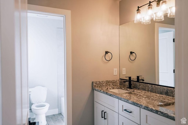 583 N Staci Dr, Hurricane, UT 84737 - bathroom featuring double vanity, toilet, a chandelier, wood finished floors, and baseboards
