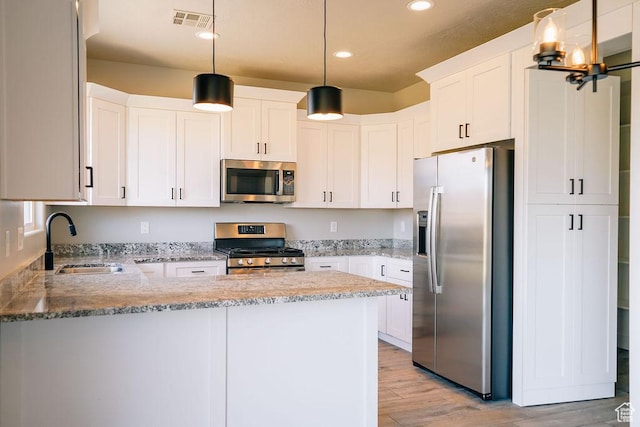583 N Staci Dr, Hurricane, UT 84737 - kitchen with stainless steel appliances, a sink, a peninsula, light stone countertops, and recessed lighting