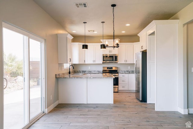 583 N Staci Dr, Hurricane, UT 84737 - kitchen featuring stainless steel appliances, a peninsula, a sink, light stone countertops, and light wood-style flooring