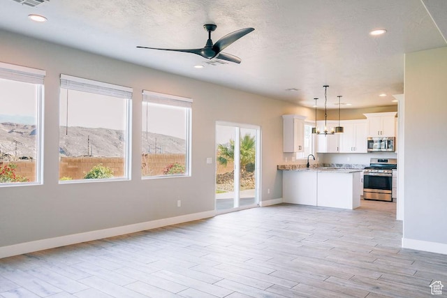 583 N Staci Dr, Hurricane, UT 84737 - kitchen with stainless steel appliances, a sink, baseboards, open floor plan, and light wood finished floors