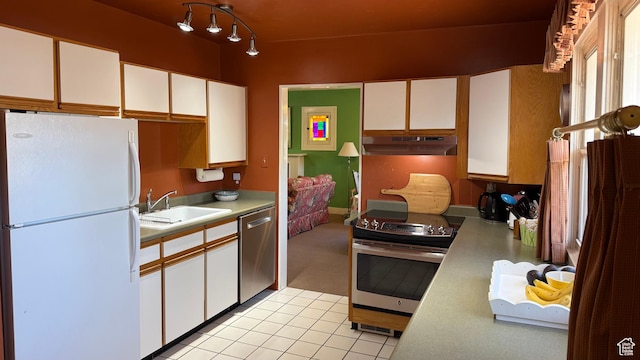 74 W Quayle Ave S, Salt Lake City, UT 84115 - kitchen with appliances with stainless steel finishes, under cabinet range hood, light countertops, white cabinetry, and light tile patterned flooring