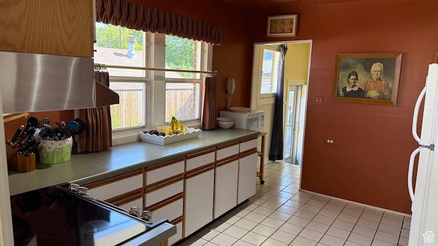 74 W Quayle Ave S, Salt Lake City, UT 84115 - kitchen featuring freestanding refrigerator, white cabinets, light countertops, and light tile patterned floors