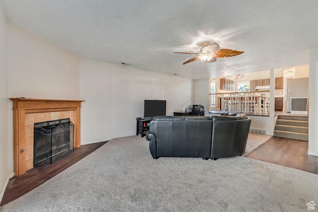 8465 S 1670 W, West Jordan, UT 84088 - carpeted living area with ceiling fan, a fireplace, wood finished floors, stairs, and baseboards