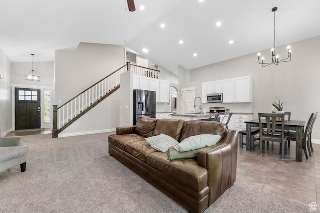 3946 W Birmingham Cir S, Jordan, UT 84009 - living area with high vaulted ceiling, a chandelier, baseboards, stairs, and recessed lighting