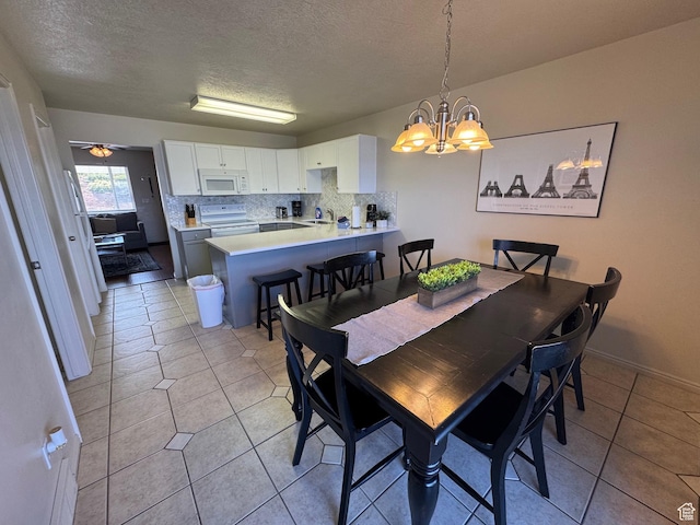 941 N Newberg Pl Unit 2, Garden City, UT 84028 - dining space featuring a chandelier, a textured ceiling, light tile patterned floors, and baseboards
