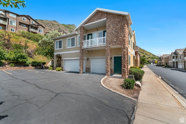 1043 Canyon Meadow Dr Unit 2, Provo, UT 84606 - view of front of property with stone siding, stucco siding, a garage, a residential view, and a balcony