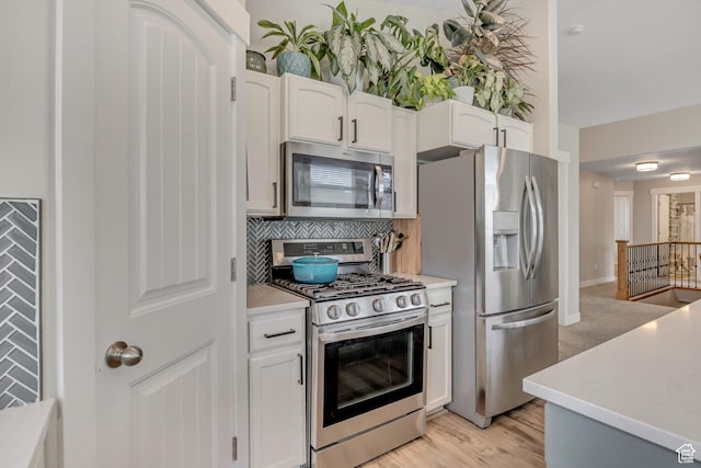 8831 W Digger Ln S, Magna, UT 84044 - kitchen featuring stainless steel appliances, backsplash, white cabinets, and light countertops