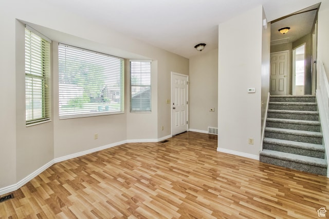 2802 W 4375 S, Roy, UT 84067 - unfurnished living room featuring light wood-style flooring, plenty of natural light, and stairs