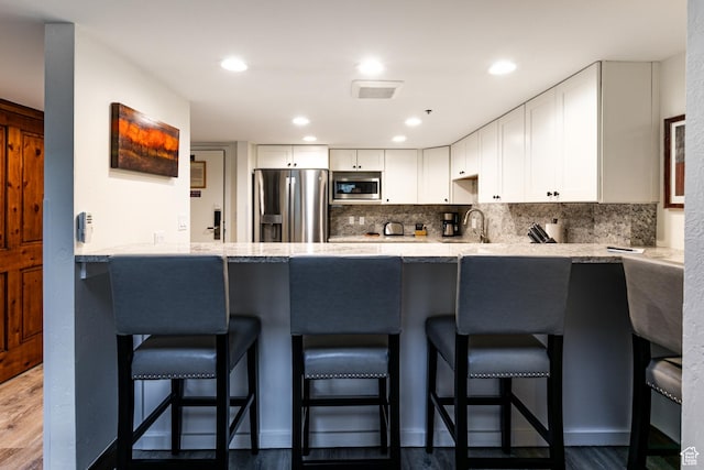 1485 Empire Ave Unit 511, Park City, UT 84060 - kitchen with appliances with stainless steel finishes, a peninsula, white cabinets, a sink, and recessed lighting