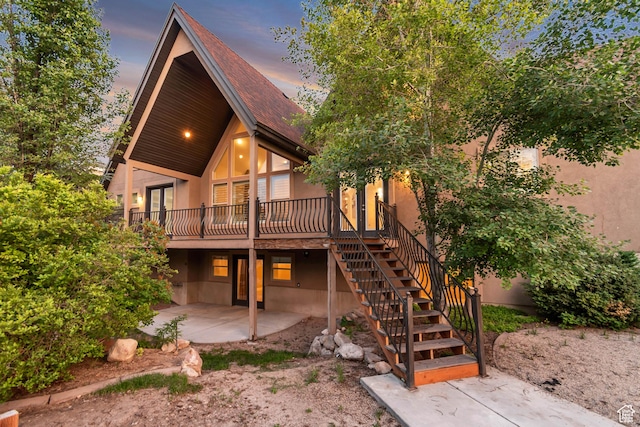 1498 W Mule Train Dr, Bluffdale, UT 84065 - back of house at dusk with a patio, a deck, stairs, stucco siding, and french doors
