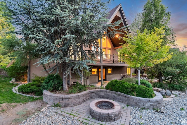 1498 W Mule Train Dr, Bluffdale, UT 84065 - view of front of home with an outdoor fire pit, a patio, stucco siding, and a deck