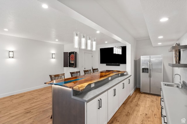 12612 S Starlite Hill Ln W, Herriman, UT 84096 - kitchen featuring stainless steel refrigerator with ice dispenser, a sink, light wood-style floors, recessed lighting, and white cabinetry