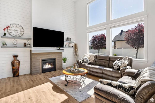 12612 S Starlite Hill Ln W, Herriman, UT 84096 - living room featuring a towering ceiling, wood finished floors, and a glass covered fireplace