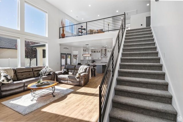 12612 S Starlite Hill Ln W, Herriman, UT 84096 - living area featuring a towering ceiling, wood finished floors, stairway, and recessed lighting