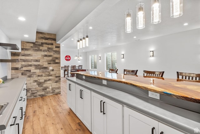 12612 S Starlite Hill Ln W, Herriman, UT 84096 - kitchen with recessed lighting, pendant lighting, light wood-style flooring, white cabinetry, and open shelves