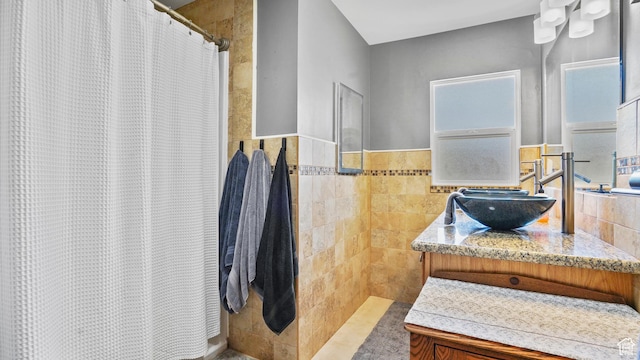 3711 Eccles E, Ogden, UT 84403 - full bath featuring plenty of natural light, a shower with shower curtain, vanity, tile walls, and a wainscoted wall