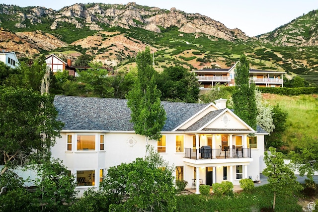 1559 E Oak Cliff Dr N, Provo, UT 84604 - rear view of property with a balcony, stucco siding, a mountain view, roof with shingles, and a chimney