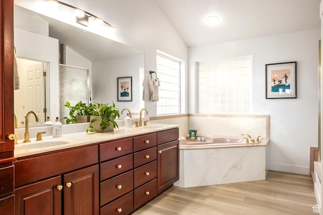 1559 E Oak Cliff Dr N, Provo, UT 84604 - full bathroom featuring vaulted ceiling, a bath, double vanity, a stall shower, and wood finished floors
