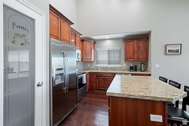 128 W 8600 S, Midvale, UT 84047 - kitchen featuring appliances with stainless steel finishes, a sink, a kitchen bar, dark wood-type flooring, and a kitchen island