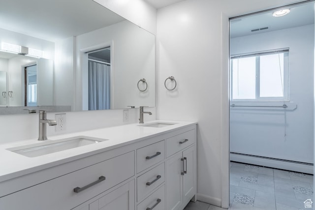 983 Westwood Dr, Pleasant View, UT 84414 - full bathroom featuring a baseboard heating unit, double vanity, and baseboards
