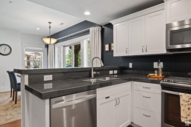 760 W Holliday Dr, Kamas, UT 84036 - kitchen with appliances with stainless steel finishes, a sink, a peninsula, white cabinets, and wood finished floors