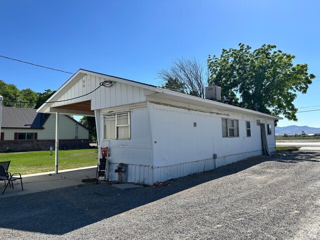 102 S 1000 W, Tremonton, UT 84337 - view of home's exterior featuring a chimney, a mountain view, cooling unit, and a lawn