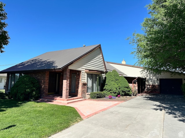 102 S 1000 W, Tremonton, UT 84337 - single story home with driveway, a front lawn, brick siding, metal roof, and an attached garage