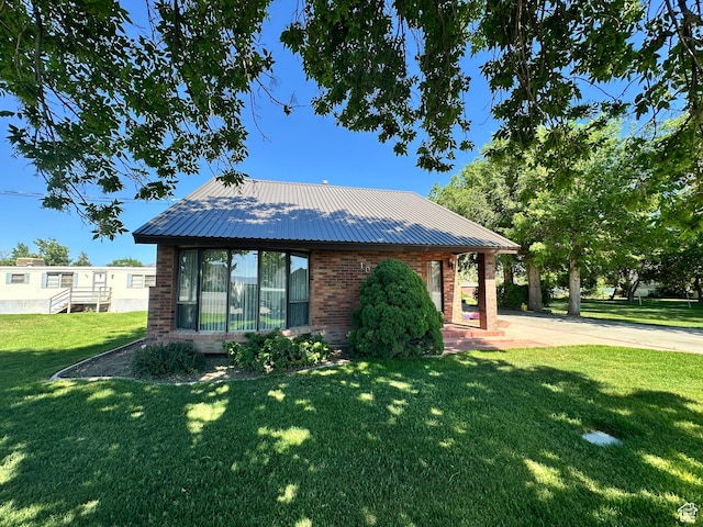 102 S 1000 W, Tremonton, UT 84337 - view of side of home with brick siding, a yard, and metal roof