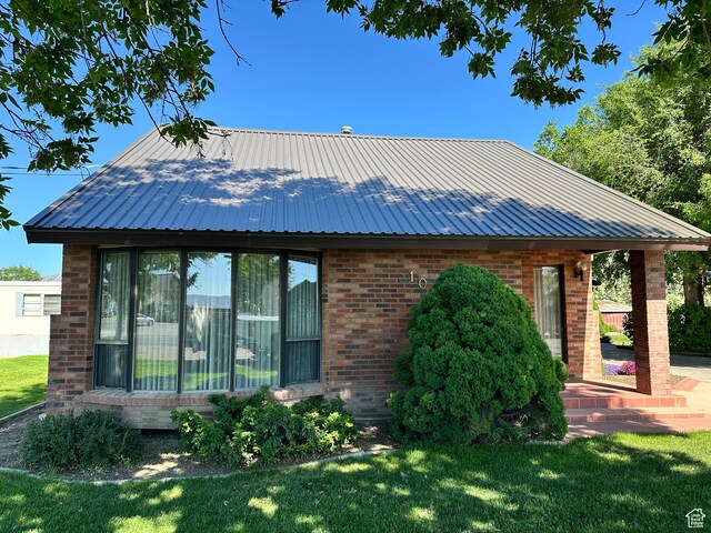 102 S 1000 W, Tremonton, UT 84337 - view of front of property with brick siding, a front lawn, and metal roof