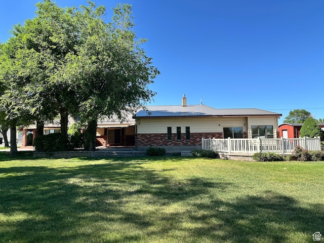 102 S 1000 W, Tremonton, UT 84337 - rear view of house with a yard, a deck, brick siding, and a chimney