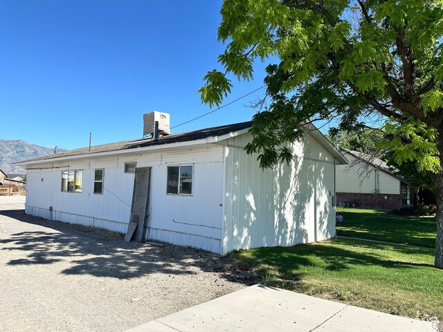 102 S 1000 W, Tremonton, UT 84337 - view of side of home with a lawn, a chimney, and a mountain view