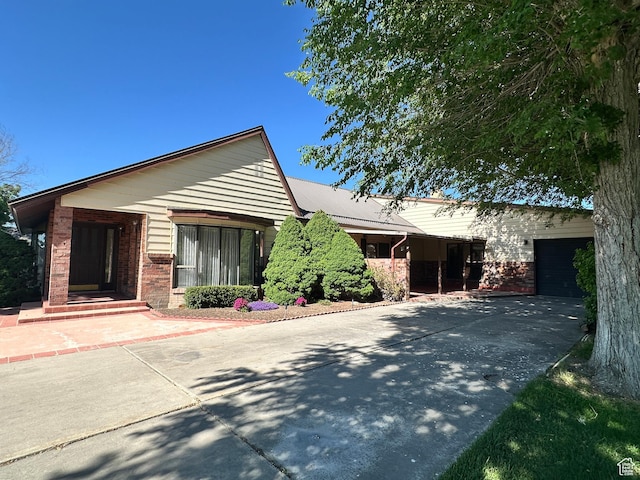 102 S 1000 W, Tremonton, UT 84337 - ranch-style home featuring concrete driveway, brick siding, and an attached garage